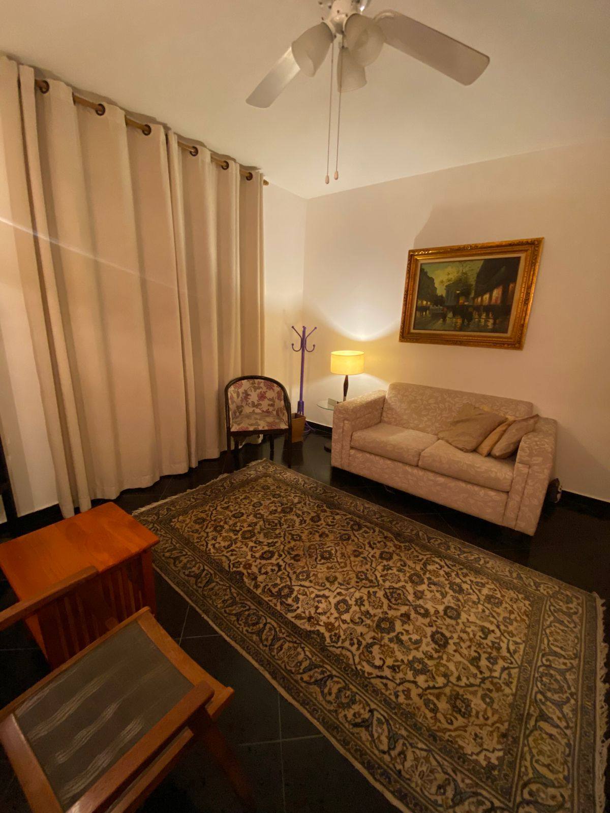 Sala de atendimento com sofá e tapete persa